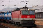 1044 012 durcheilt mit einem Tank-Containerzug den Bahnhof von Amstetten in Niedersterreich.