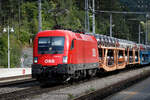 1116 273 zieht einen Güterzug mit Neuwagen von Gloggnitz kommend Richtung Semmering durch den Bahnhof Payerbach Reichenau.