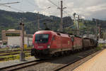 Bahnhof Innsbruck am 1. Juni 2018. Im Hintergrund ist die Skisprungschanze zu sehen. Im Vordergrund ein Güterzug mit 1116 174-4 und 1144 069-2. 