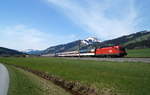 Bei vorfrühlingshafter Stimmung ist der Plan-Paradezug der Salzburg-Tiroler-Bahn, der Eurocity  Transalpin  (163), auf seinem Weg von Zürich HB nach Graz Hbf nahe Brixen im Thale unterwegs und wird in wenigen Minuten gering verspätet den Bahnhof Kirchberg in Tirol erreichen, 22.04.2019.