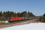 1116 057 mit einem gemischten Güterzug aus Salzburg kommend am 2. März 2023 bei Sossau im Chiemgau.