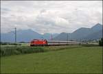 1116 045 legt sich vor den Chiemgauer Bergen mit dem EC 114  WRTHERSEE , auf der Reise von Klagenfurt Hbf nach Dortmund Hbf, in die Kurve.