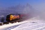 Die 1116 153  ÖAMTC  der ÖBB vor einem Railjet im Morgennebel am 28.01.17 bei Sossau in der Nähe von Grabenstätt.