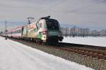 Die 1116 130-6 der ÖBB „E-Card Lok“ mit einem Personenzug am 14.02.15 bei Übersee am Chiemsee