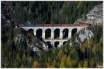 Die blutorange 1142 567, quert mit einem Gterzug das 87m lange und 36m hohe Krausel Klause Viadukt am Semmering.