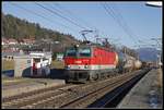 1144 071 fährt am 18.12.2018 mit einem Güterzug durch die Haltestelle St.Georgen am Längsee.