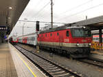 1144 210 wartet mit REX 5362 auf die Abfahrt nach Landeck-Zams. Im Hintergrund wartet ein Talent als S-Bahn nach Ötztal ebenfalls auf die Ausfahrt. Aufgenommen während eines starken Gewitterregens in Innsbruck Hbf am 13.07.2021