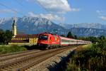 Ein idyllisches Bild - 1216.016 passiert am 22. August 2015 mit ihrem EC 84 das Kloster Reisach bei Niederaudorf. Im Hintergrund die eindrucksvolle Bergkulisse von Zahmen und Wildem Kaiser. Und doch gibt es einen Bezug zum Weltgeschehen und gesellschaftlichen Herausforderungen. Aktuell werden die EuroCities zwischen Italien und Deutschland von zahlreichen Flüchtlingen und Asylsuchenden genutzt, die auf ein besseres Leben hoffen. Oft sind die Züge verspätet, der Grund lautet zumeist  polizeiliche Ermittlungen ....