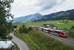 Vor dem Panorama der Hohen Salve schlängelt sich der REX 1521 (Wörgl Hbf - Schwarzach-St. Veit) bei Kirchberg Bockern um die Kurve. Die Aufnahme stammt vom wolkenverhangenen 25. Juli 2020, an dem die Leistung von den beiden Salzburgern 4023 001 und 4023 002 geführt wurde. Dabei handelt es sich um die ältesten Triebzüge der ÖBB-Talent-Triebwagen, die zum Zeitpunkt der Aufnahme 16 Jahre alt waren.