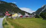 Eisenbahnidylle in Scharnitz: Hier auf der Mittenwaldbahn scheinen die Uhren noch etwas langsamer zu ticken. Man findet noch unbeschrankte Bahnübergänge mit Glocke und Lichtzeichenanlage, die Altbaustrecke ist durchgehend eingleisig, es gibt kaum  Lärmschutzwände und die Höchstgeschwindigkeit liegt bei 70 km/h. Am hochsommerlichen 5. Juli 2020 war der 4024 073-1 als REX 5417 aus Garmisch-Partenkirchen kommend auf dem Weg Richtung Innsbruck Hbf und hat soeben den Bahnhof Scharnitz verlassen, um nun vor dem malerischen Hintergrund der Pfarrkirche Maria Hilf und der umliegenden bewaldeten Berge Seefeld anzusteuern.