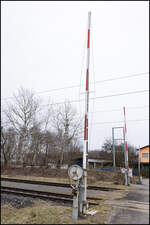 Ein kleiner Bahnübergang nächst den Toren der nicht befahrenen Gleise der AB Mellach wird mit einem Handschranken gesichert .