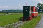 Kurz nach der Abfahrt in Mäder befindet sich am 30.05.2019 die von der Orenstein & Koppel AG Montania unter der Nummer 11950 gebaute Feldbahnlok mit einem Personenwagen auf der Fahrt zum Werkhof beim Steinbruch Kadelberg.