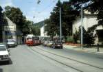 Wien WVB SL 43 (E1 4847) Dornbach, Dornbacher Strasse im Juli 1992. - Der Zug hat gerade die Abfahrtshaltestelle der Endstation Neuwaldegg verlassen. - Rechts sieht man einen Teil der neubarocken St-Anna-Kapelle, die in der Mitte der Strassenbahnschleife liegt.