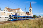 Wiener Neudorf. Vor dem prunkvollen Rathaus in Wiener Neudorf bahnt sich ein Tandem der Baureihe 500 der Badner Bahn am 30.08.2026 ihren Weg nach Baden.