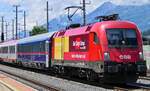 1016 023 in neuer Werbefolierung für Transporeon mit dem EC 163 "Transalpin" nach Graz Hbf am 30.05.2024 bei der Durchfahrt im Bahnhof Kundl.