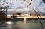 Von der tiefstehenden Wintersonne beschienen erreicht der 5 Minuten verspätete REX 5329 nach Zell am See am 15.12.2024 Brixlegg und überquert den Inn unmittelbar vor der dortigen