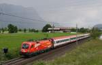 Die neu getaufte 1116 072-0 ``Bodensee`` der ÖBB Rail Cargo Group in Zusammenarbeit mit der Firma Gebrüder Weiss (Gemeinsam Erfolge Transportieren)ist am 3.6.2014 mit dem IC 860 ``St. Anton am Arlberg`` von Wien West nach Bregens unterwegs. Hier bei Kirchbichl im Tiroler Unterland mit Blick auf den Berg  Pendling, der im Regen verschwindet.
