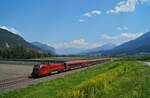 1116 202 schiebt den circa 45 Minuten verspäteten RJX 165 Richtung Wien am 30.07.2020 auf der Arlbergbahn an der malerischen Ortschaft Flaurling vorbei.