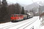 Im winterlichen Bahnhof Semmering steht bei leichtem Schneefall am 10.1.2026 2143 070 vom Verein  Neue Landesbahn  mit fünf Wagen und wartet auf ihrem Weg von Fehring nach Mistelbach auf die Weiterfahrt.