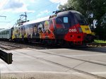 1116 153-8 "ÖAMTC", passiert bei Bruck/L einen Bahnübergang; 160614