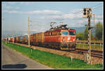 1042 030 fährt am 28.04.1995 mit einem langen Güterzug bei Niklasdorf durchs Murtal.