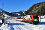 Am 26. Dezember 2018 bespannte die 1116.159 den EC 163 zwischen Buchs SG und Graz HBF. Mit ihrer auffälligen Gestaltung erinnert die Lok an das Jubiläum 150 Jahre Brennerbahn und an die auf dieser wichtigen Alpenquerung eingesetzten Fahrzeuge. Eigentlich hatte ich mir für diesen Zug ein anderes Motiv ausgedacht, das an den kürzesten Tagen aber im Schatten liegt wie ich vor Ort feststellen musste. Daher wurde kurzfristig umdisponiert und die Bahnhofseinfahrt Hochfilzen als Standpunkt gewählt. Der Notbehelf gefällt mir im Nachhinein sogar ganz gut, die frisch verschneite Landschaft hat aber einen nicht unerheblichen Anteil daran. 