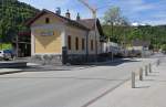 Der Bahnhof von Andelsbuch ist per Eisenbahn zwar nicht mehr erreichbar, erstrahlt aber im  Hochglanz . Zwei abgestellte Gterwaggons, einer davon ist ganz links im Bild in grner Farbe erkennbar fristen ihr Dasein auf einem Schienenstrangrest im Bahnhofsbereich. Mai 2012