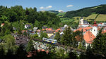 Der  klassike  Blick auf das Viadukt in Waidhofen wurde vor einigen Jahren durch Pflanzung einiger Fichten zerstört. Doch das Motiv ist noch immer machbar, von dem Wald aus, zu den Türmen der Stadt kommen am Bildrand die besagten Fichten. An einem heissen Sommertag dem 21.07.2015 erreicht der R 6920, gebildet aus VT 10, kurz seinen Endbahnhof. 