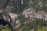 Ein Railjet ist an einer der schönsten Stellen der Semmeringbahn mi Krauseltunnel, Krauselklauseviadukt und Polleroswandtunnel unterwegs. Das Bild entstand vom sogenannten Zwanzig - Schilling - Blick mit einem Teleobjektiv am 23.11.2017.