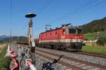 Am sonnigen 2.5.2025 steht die 1144 043 als Arbeitszuglok im Bahnhof St.Martin am Grimming und wartet mit einigen Materialwagen auf die Abfahrt nach Stainach-Irdning.