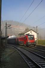 Im einzigen Sonnenfenster durchfährt RJ-15555 mit 1116.227 mit dem leicht Nebelverhangenen Kurhaus die Hst.Wolfsbergkogel am 23.11.14
