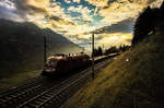 Der Tag geht zu Ende und 1116 134-8 fährt in den letzten Sonnenstrahlen mit einem Güterzug die Tauernbahn-Südrampe hinunter.