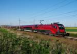 1116 233 war am 28. April 2012 mit dem  Railjet 662  powered by Urlaub am Bauernhof  auf der Westbahn unterwegs, aufgenommen bei Oftering.