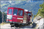 Nach einer Zugbegegnung im Bahnhof Schafbergalm schiebt sich ein weiterer Zug gefüllt mit Touristen den Schafberg hoch .