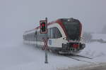 Auf leisen Solen rollt die Eisenbahn über die Gleise wenn Schnee liegt.