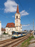 Am Alten Rathaus von Wiener Neudorf vorbei, fuhr Tw 103 der Wiener Lokalbahn am 04.04.2022 von Wien Kärntner Ring nach Baden Josefsplatz, zusammen mit einem Triebwagen der Reihe 400.