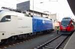 Gefhrlicher Job: Ein Bahndisponent bergibt ein betriebliches Dokument an den Talent-Fahrzeugfhrer, whrend im Rcken Taurus ES 64 U2-002 der Wiener Lokalbahnen vorbeidonnert.