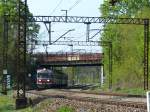 EN57-1239ra schlängelt sich durch die Kurve unter der Eisenbahnbrücke.