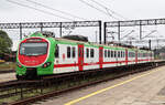 Farbiger Lokalzug EN57AL-1551 in einem Unterwegsbahnhof zwischen Elk und Grajewo.