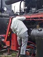 Ein Mechaniker kontrolliert und lt die BR 23 1019 beim Halt in Sulechw (27.04.2013).