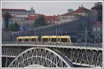 Metro do Porto. Vor einem Teil der Stadtmauer von Porto hat eine Doppeleinheit der Metro die Brckenmitte erreicht. (14.05.2011)