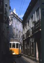 Hier wird's richtig eng: Lissabon Tw 710 am 13.09.1990 in der Rua das Escolas Gerais (Alfama). Nach der Aufnahme war es angebracht, sich in einen Hauseingang zurckzuziehen. An engen Stellen wie dieser ist es unmglich, die Fahrleitung so mittig anzubringen, da der Bgel-Stromabnehmer jederzeit Kontakt hat. Daher fhrt die legendre  28  hier mit Rollen-Stromabnehmer.