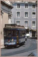 Triebwagen 723 der Linie 28 quitscht durch die engen Gassen der Alfama in Lissabon.
