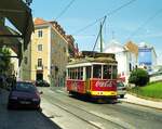 Lissabon Elétricos__Tw 554 auf Linie 28 nach Carreira hat die erste Steigung erklommen. Rechts der Straße bietet sich ein beeindruckendes Panorama über die Unterstadt. Auf dem Tw-Dach kann man die zweierlei Stromabnehmer erkennen. Der Einholmstromabnehmer kommt bei den für die Niederflurfahrzeuge 1995 umgebauten Fahrleitungen der Linien 15, 18, 25 zum Einsatz. Der Rollenstromabnehmer wird auf den eng bebauten Strecken durch die Alfama (Linien 12 und 28) gebraucht, weil dort das Lichtraumprofil für den Einholmstromabnehmer nicht überall ausreichend wäre.__06-1999