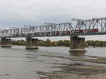 Hier überquert gerade ein Personenzug die Eisenbahnbrücke über den Ob in Nowosibirsk am 13.