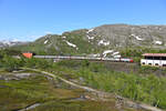 Der norwegische Teil der Erzbahn nach Narvik heißt Ofotbanen und führt von der Grenze in den Bergen hinunter nach Narvik an den Atlantik. Am Nachmittag des 28.06.2022 ist der Nachtzug 93 nach Stockholm kurz von dem Grenzbahnhof Bjørnfjell unterwegs.