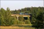 Blaue Linie nach Akalla, Kymlinge -    Nach der Station Hallonbergen fährt die U-Bahn zwei Kilometer weiter im Tunnel um dann in unbebauter Landschaft auf einer Brücke eine Talsenke zu