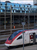Neigezug vor geneigten Glasscheiben -    ICN im Bahnhof Basel SBB.