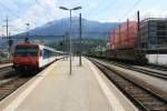 Ein RBDe 560 NPZ und zwei Re 4/4 der BLS mit einem Hangartner-zug stehen in Bahnhof Brig.