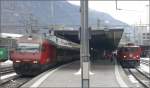 460 004-5 trifft am gemeinsamen Bahnsteig in Chur auf Ge 6/6 II 704  Davos .